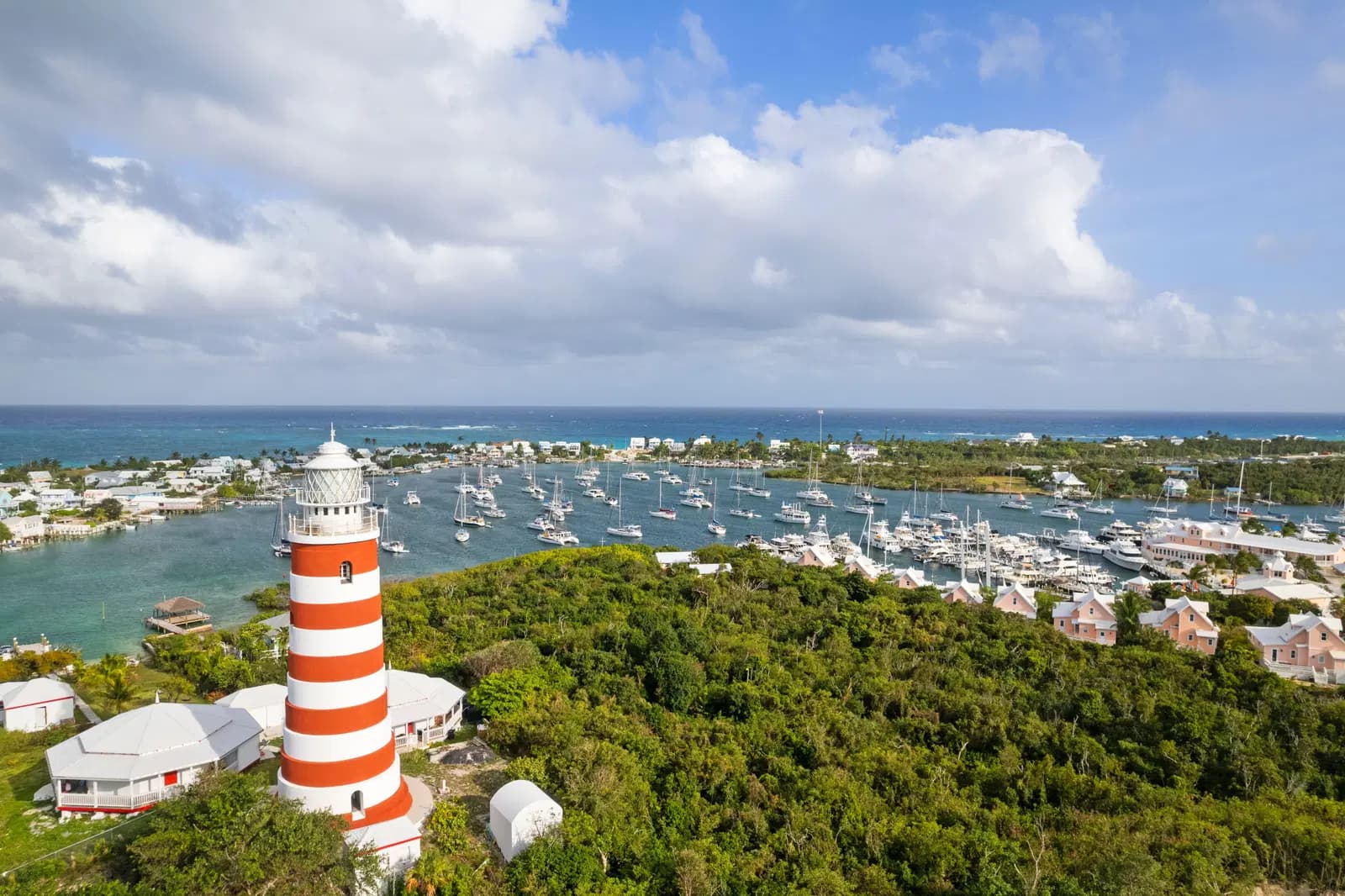 The Hope Town lighthouse above the harbour on Elbow Cay, moored boats and pastel roofs below it