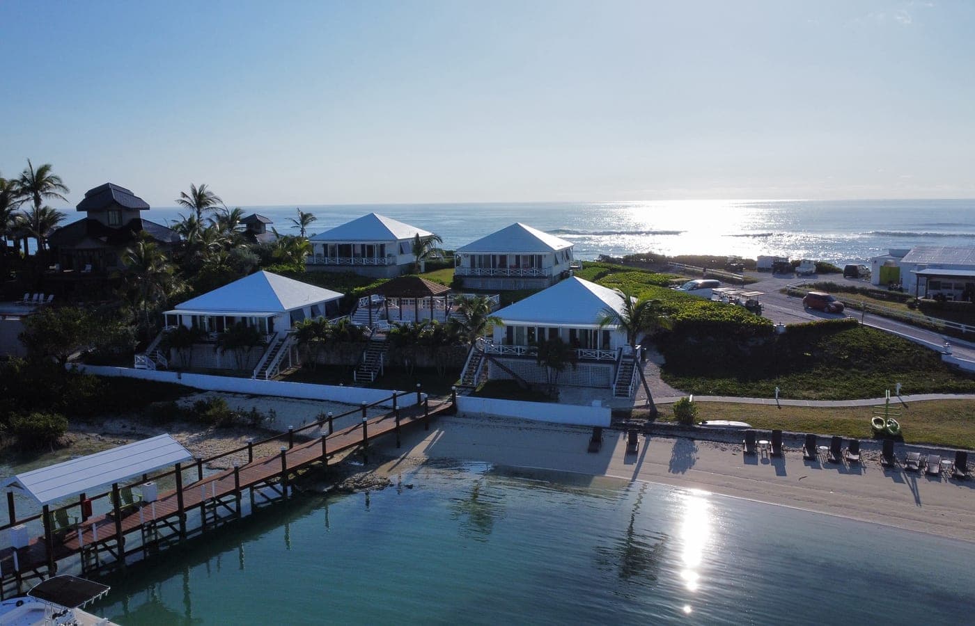 Golden-hour aerial of the cottages above the beach