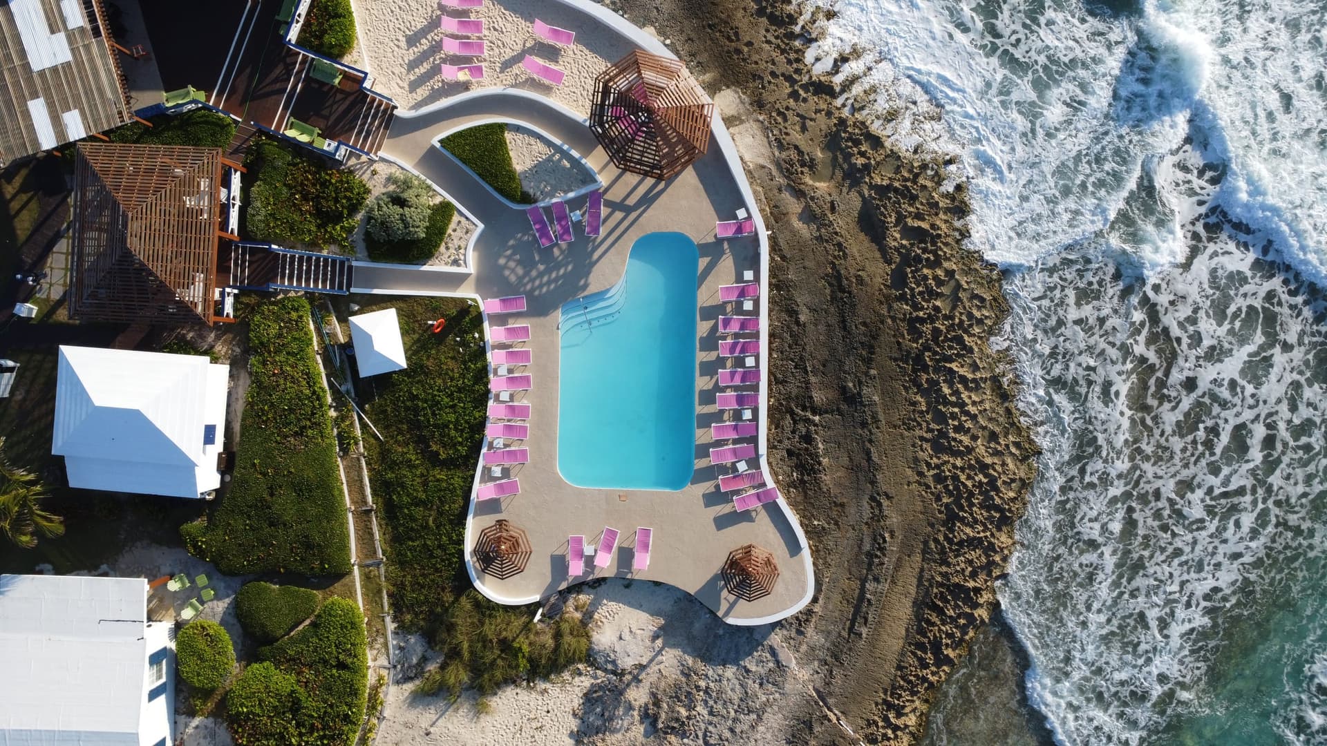 The freshwater pool on its point, ringed by loungers