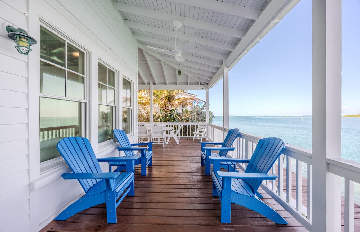 Adirondack chairs on a covered porch over the water